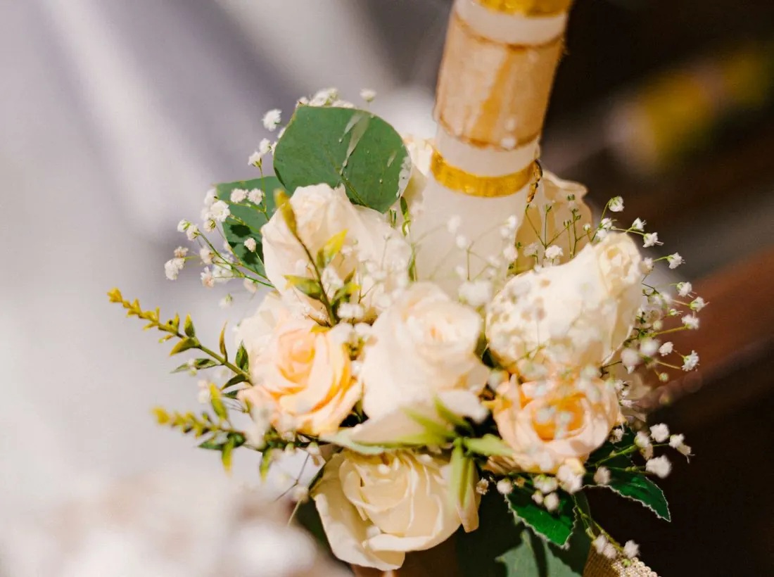 Detalle elegante de un ramo de flores y una vela sobre una mesa de celebración