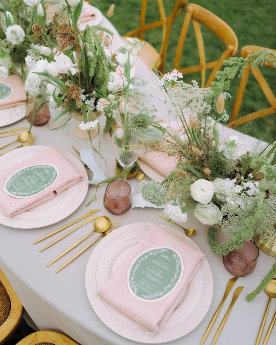 Detalle de manos preparando la decoración de una mesa con mimo